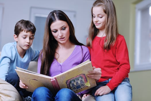 young mom play with their kids at home and reading book photo