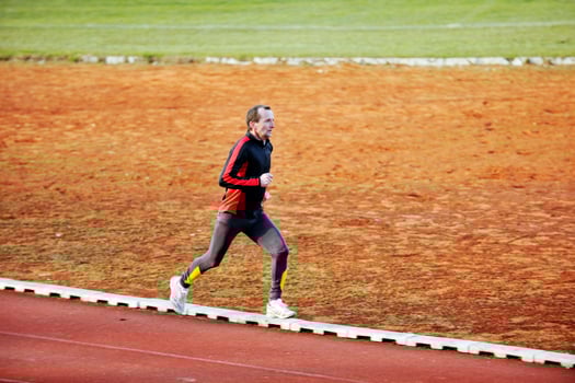 adult man running on athletics track photo