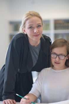 female teacher helping students on class photo