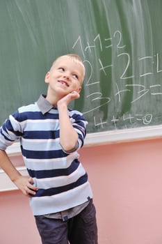 happy young boy at first grade math classes photo