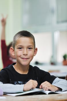 happy young boy at first grade math classes photo
