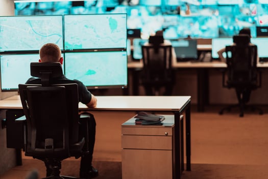 Male security operator working in a data system control room offices Technical Operator Working at workstation with multiple displays, security guard working on multiple monitors Male computer opera photo