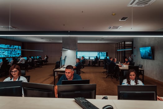 Group of Security data center operators working in a CCTV monitoring room looking on multiple monitors Officers Monitoring Multiple Screens for Suspicious Activities Team working on the System Contr photo