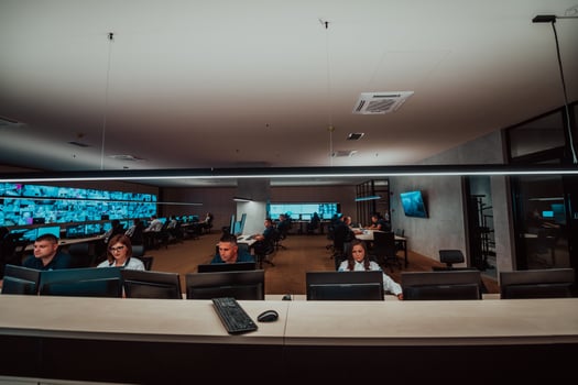 Group of Security data center operators working in a CCTV monitoring room looking on multiple monitors Officers Monitoring Multiple Screens for Suspicious Activities Team working on the System Contr photo