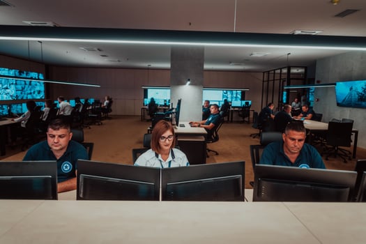 Group of Security data center operators working in a CCTV monitoring room looking on multiple monitors Officers Monitoring Multiple Screens for Suspicious Activities Team working on the System Contr photo