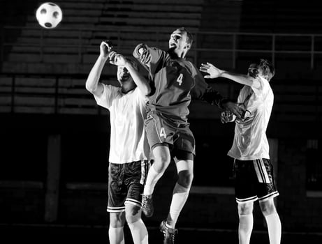 football players in action for the ball photo