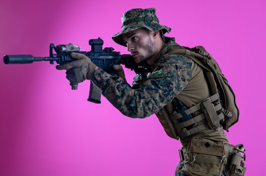 soldier in action aiming laseer sight optics pink background photo