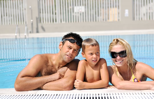 happy young family have fun on swimming pool photo