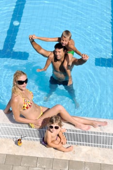 happy young family have fun on swimming pool photo