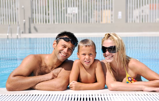 happy young family have fun on swimming pool photo
