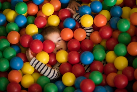 boy having fun in hundreds of colorful plastic balls photo