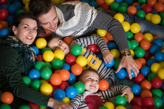 young parents with kids in a children's playroom photo