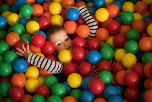 boy having fun in hundreds of colorful plastic balls photo