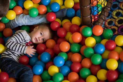 boy having fun in hundreds of colorful plastic balls photo