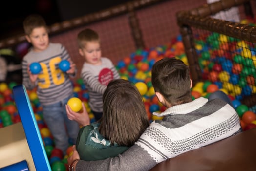 young parents with kids in a children's playroom photo