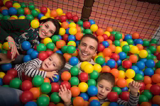 young parents with kids in a children's playroom photo