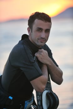 Portrait of a young  kitsurf  man at beach on sunset photo
