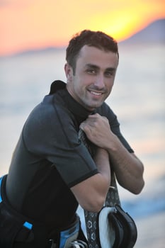 Portrait of a young  kitsurf  man at beach on sunset photo