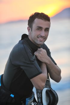 Portrait of a young  kitsurf  man at beach on sunset photo
