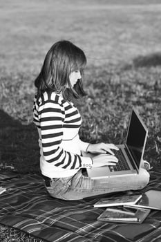 young teen girl work on laptop outdoor photo
