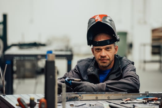 Professional Heavy Industry Welder Working Inside factory, Wears Helmet and Starts Welding. Selective Focus photo