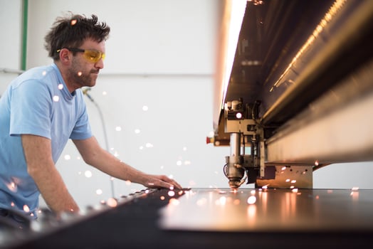Within heavy industry. A man works in a modern factory on a CNC machine. Selective focus photo
