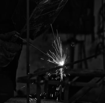a black and white photo of a man welding