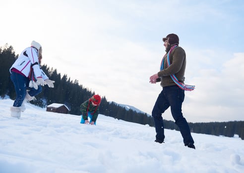 happy family playing together in snow at winter photo