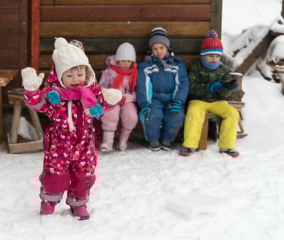 little children group sitting  together  in front of wooden cabin photo