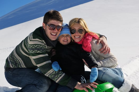 family having fun on fresh snow at winter vacation photo