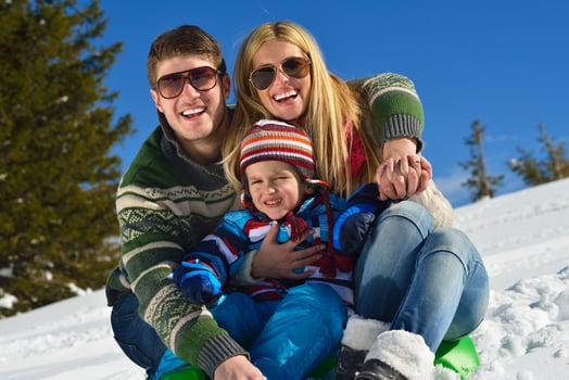 family having fun on fresh snow at winter photo