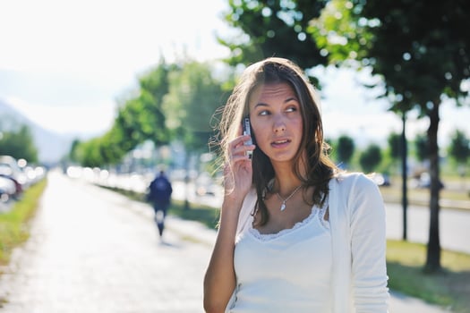 young woman talk by cellphone on street photo