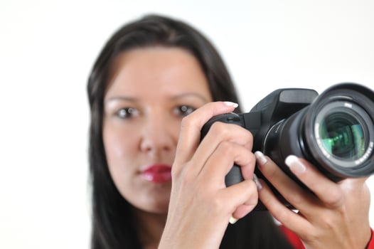 Young woman holding camera in hand taking picture isolated photo