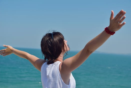 happy young woman with spreading arms to sky photo