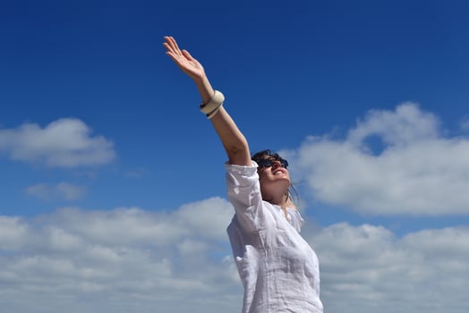 happy young woman with spreading arms to sky photo