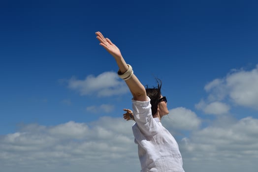 young woman with spreading arms to sky photo