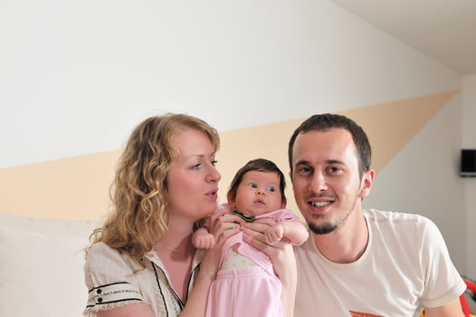 indoor portrait with happy young family and  cute little babby photo