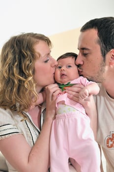 indoor portrait with happy young family and  cute little babby photo
