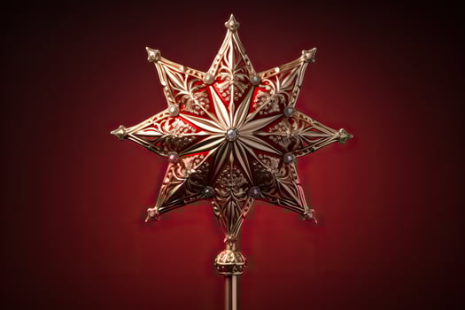 Victorian style Christmas tree topper a golden star gleaming with sparkle isolated on a holiday red gradient background photo
