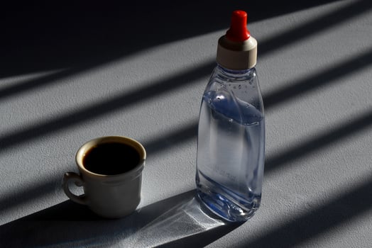 person sweetening coffee with liquid sweetener photo