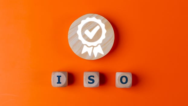 ISO quality control certification concept, top view of wooden blocks with word ISO and certificate sign. on an orange background. photo