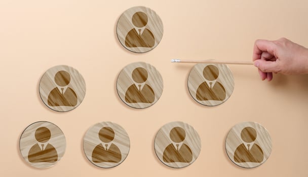 Circular wooden plaques with personnel icons and a hand, representing the concept of organizational structure photo