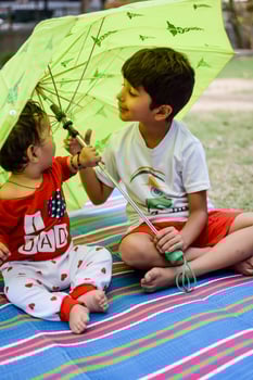 Two happy boys in society park, happy Asian brothers who are smiling happily together. Brothers play outdoors in summer, best friends. Toddler baby boy playing with his happy brother in the garden photo