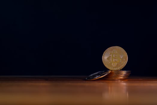 Golden Bitcoin on wooden floor. Gold digital coin on pile of coins with black background. photo