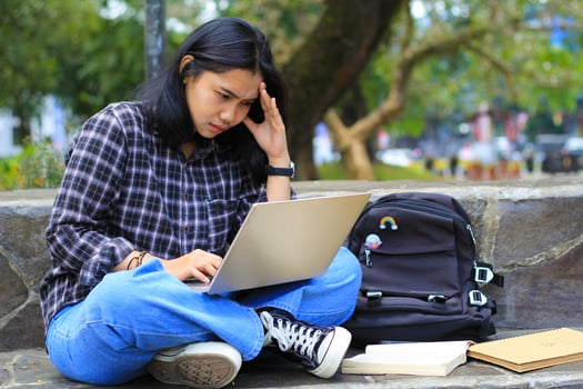 exhausted and stressed asian woman student working using laptop and study with text books in outdoors photo