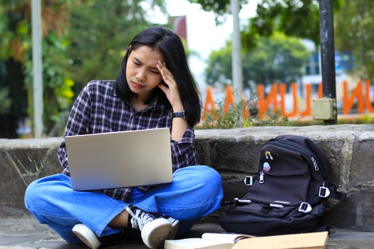 exhausted and stressed asian woman student working using laptop and study with text books in outdoors photo