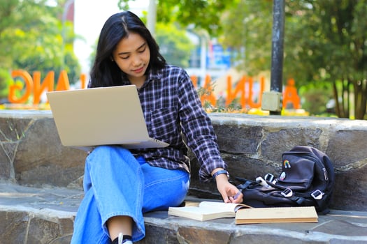 young smiling asian woman using laptop and writing notebook, cheerful asian student watching webinar and studying from e course photo