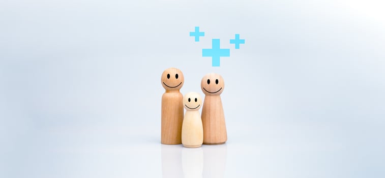 The concept of health insurance and Medical welfare. A family of wooden dolls with a plus sign on a white background represents protection, receiving benefits. health care planning photo