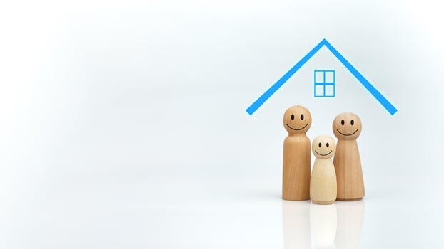 The concept of health insurance and Medical welfare. A wooden doll with a blue house on a white background represents protection, receiving benefits. Health insurance and access to treatment. photo