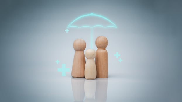 The concept of health insurance and Medical welfare. A family of wooden dolls with an umbrella and a plus sign on a white background represents protection, receiving benefits. health care planning photo